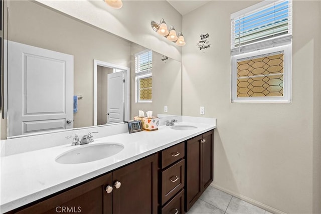 full bathroom with tile patterned flooring, double vanity, baseboards, and a sink