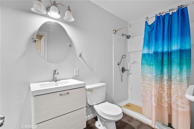 full bathroom featuring vanity, wood finished floors, a shower stall, and toilet