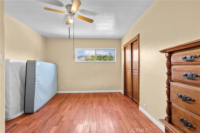 interior space featuring light wood-style flooring, baseboards, and ceiling fan