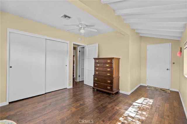 unfurnished bedroom featuring visible vents, lofted ceiling with beams, wood finished floors, a closet, and baseboards