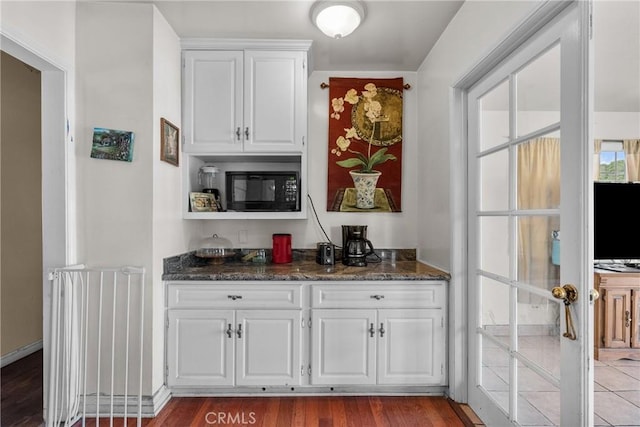 bar featuring black microwave and wood finished floors