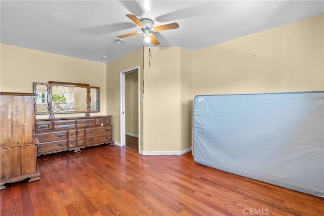 bedroom featuring visible vents, baseboards, wood finished floors, and a ceiling fan