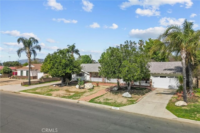 obstructed view of property with concrete driveway and fence