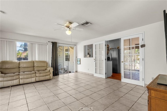 living room with light tile patterned floors, visible vents, ceiling fan, and french doors