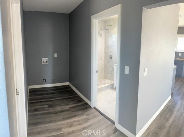 hallway with baseboards and wood finished floors