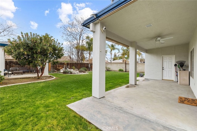 view of yard with a fenced backyard, ceiling fan, and a patio