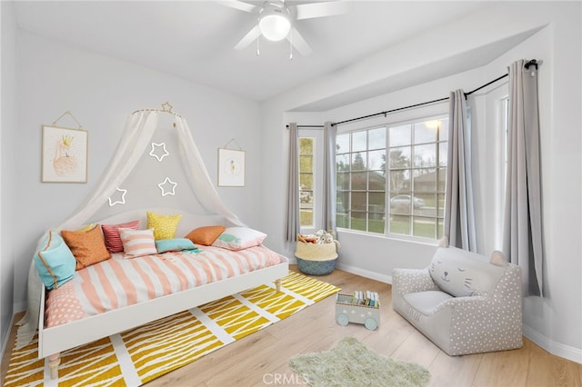 bedroom featuring a ceiling fan, baseboards, and wood finished floors