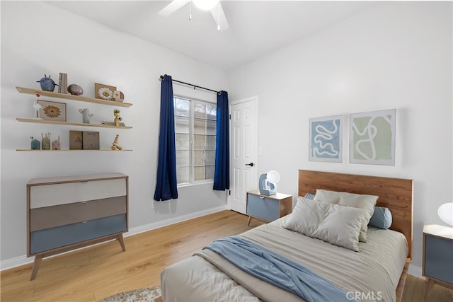 bedroom with ceiling fan, baseboards, and wood finished floors