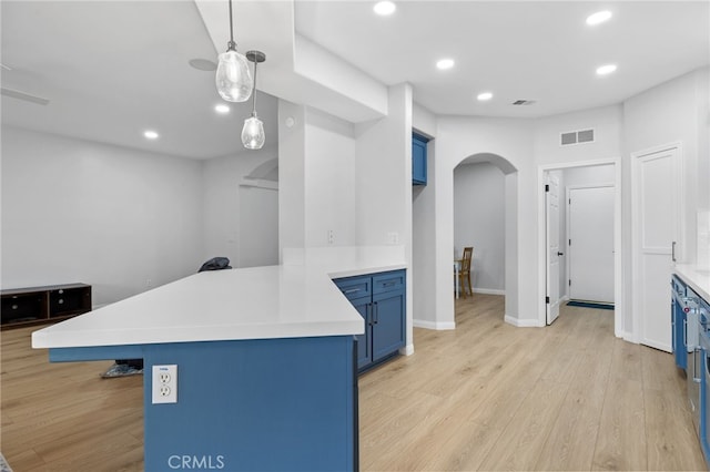 kitchen with arched walkways, blue cabinetry, a peninsula, and light countertops