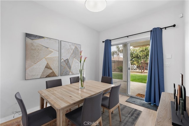 dining room with light wood-type flooring and baseboards