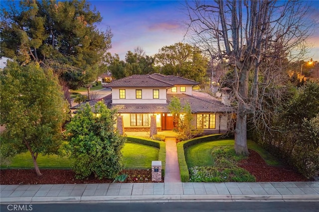 view of front of house featuring a lawn and stucco siding