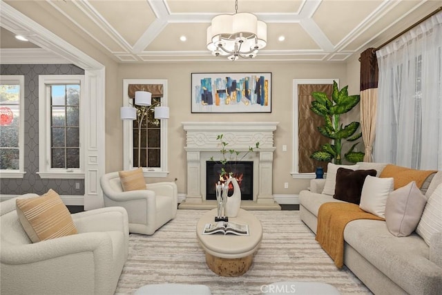 living area with a glass covered fireplace, a notable chandelier, coffered ceiling, and ornamental molding