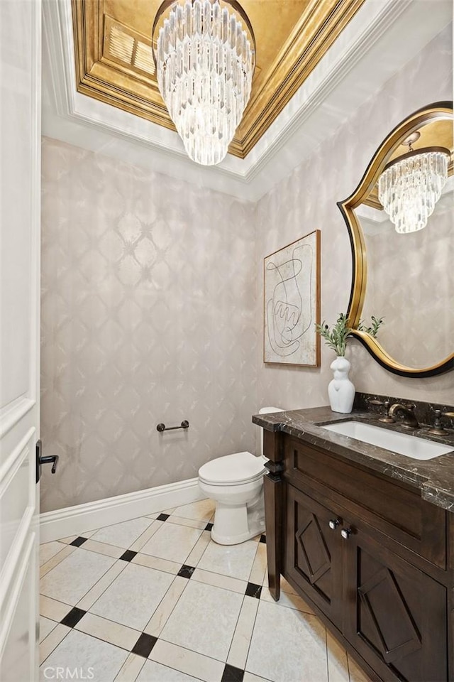 half bathroom with a chandelier, crown molding, a tray ceiling, and baseboards