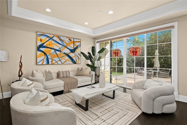 living room with crown molding, baseboards, recessed lighting, wood finished floors, and a raised ceiling