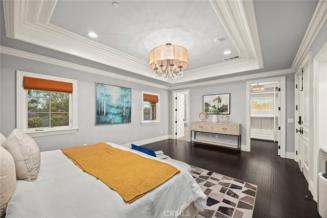 bedroom featuring visible vents, crown molding, a tray ceiling, an inviting chandelier, and wood-type flooring