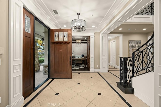 entrance foyer featuring visible vents, baseboards, a chandelier, ornamental molding, and recessed lighting