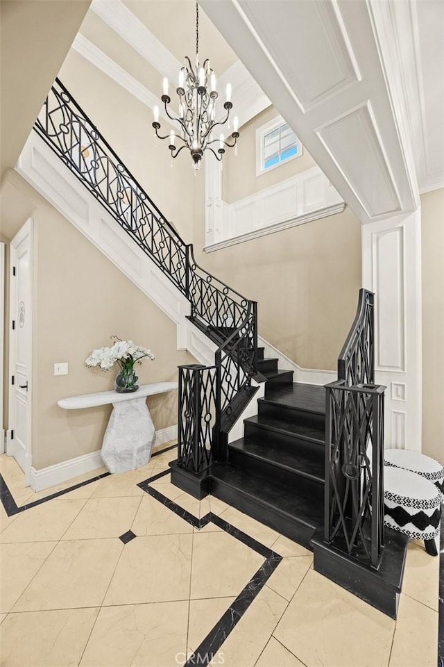 stairway with an inviting chandelier, crown molding, and baseboards