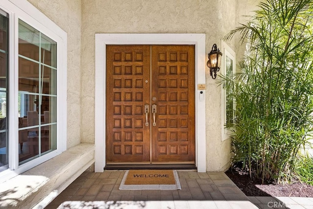 entrance to property featuring stucco siding