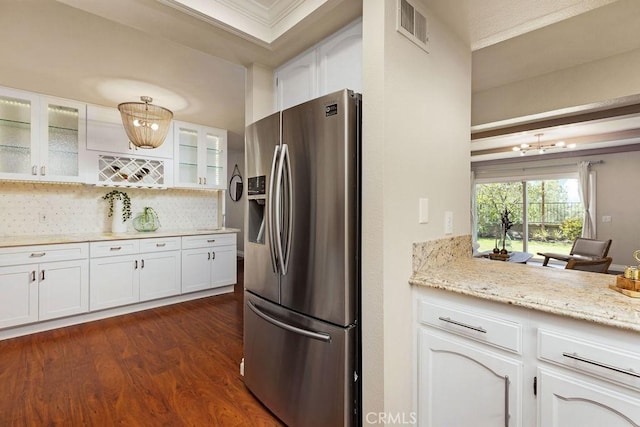 kitchen with visible vents, dark wood-type flooring, white cabinets, glass insert cabinets, and stainless steel fridge