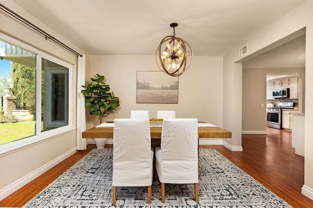 dining room with a wealth of natural light, a notable chandelier, visible vents, and dark wood-style floors