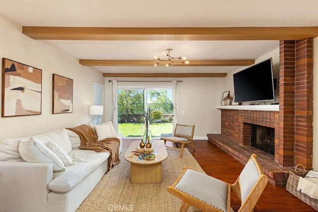 living area featuring beam ceiling, a brick fireplace, wood finished floors, and baseboards