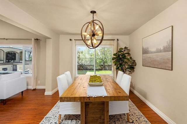 dining area with baseboards, an inviting chandelier, and dark wood finished floors