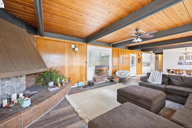 living area featuring beamed ceiling, wood finished floors, wooden ceiling, and wood walls