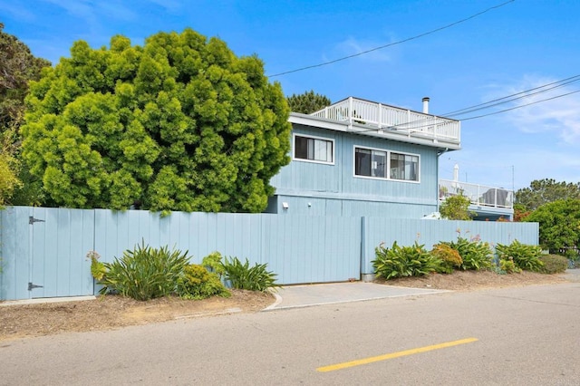 view of property exterior with a balcony and fence