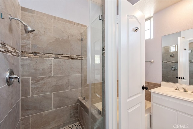 bathroom with vanity and tiled shower