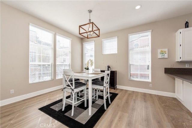 dining area with baseboards, plenty of natural light, and light wood-style flooring