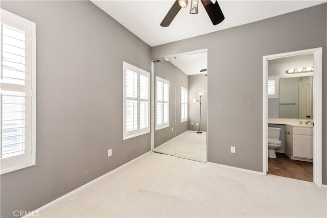 bedroom featuring carpet, baseboards, ceiling fan, a closet, and connected bathroom