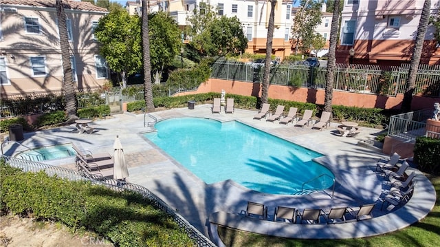 community pool with a patio and fence