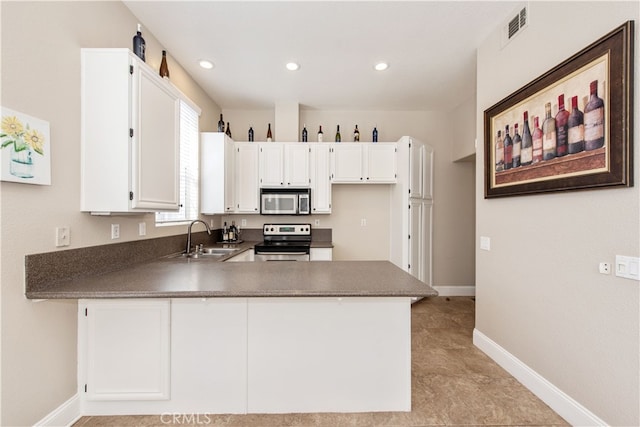 kitchen with visible vents, a peninsula, a sink, appliances with stainless steel finishes, and dark countertops