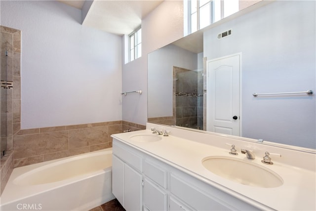 full bath with a sink, a bath, and a tile shower