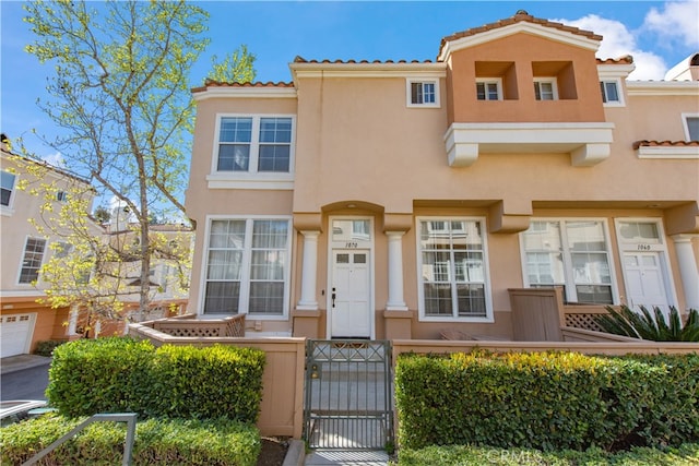 multi unit property featuring a gate, a fenced front yard, and stucco siding