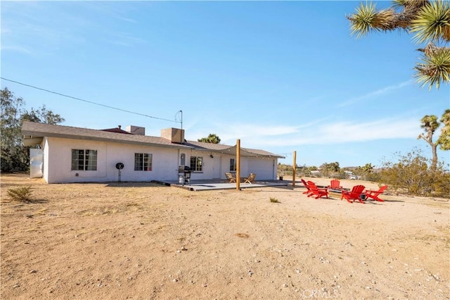 rear view of property with stucco siding and a patio