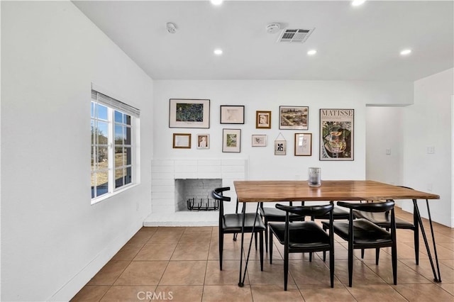 tiled dining room with visible vents, recessed lighting, a brick fireplace, and baseboards