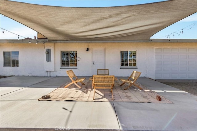 exterior space with a patio, electric panel, and stucco siding