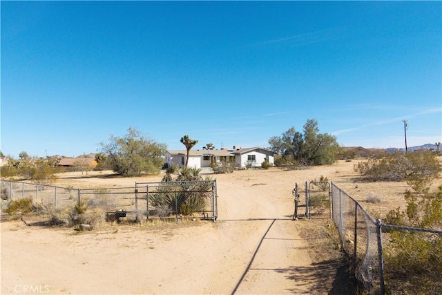 view of road with a gated entry, a rural view, driveway, and a gate