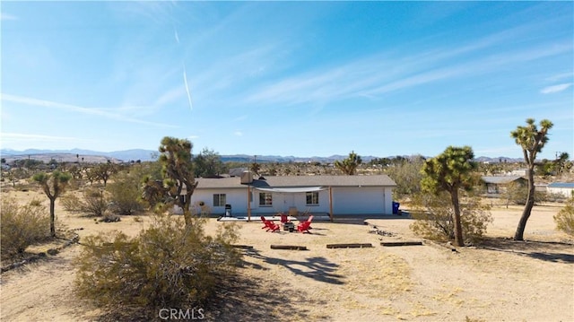 single story home featuring a mountain view, a garage, and dirt driveway