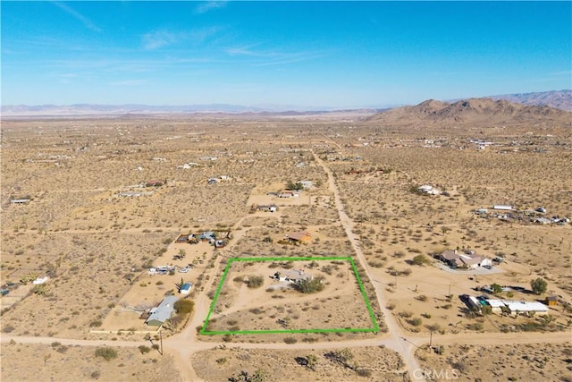 drone / aerial view featuring view of desert, a rural view, and a mountain view