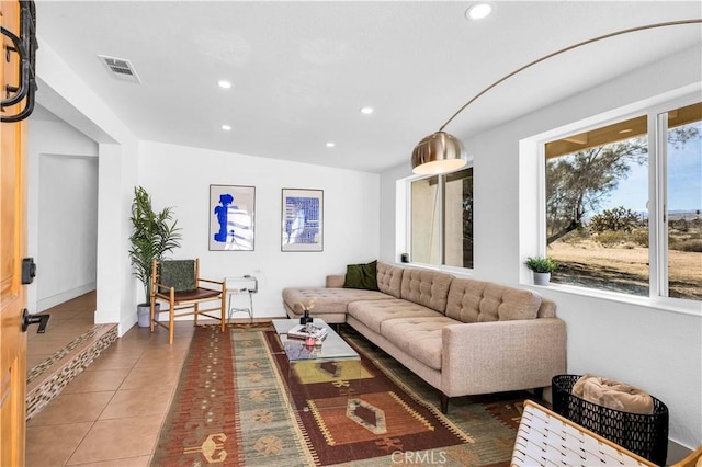 living area with tile patterned flooring, visible vents, recessed lighting, and baseboards