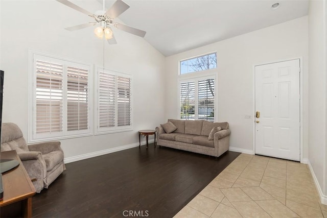 living area featuring lofted ceiling, light wood-style flooring, baseboards, and ceiling fan