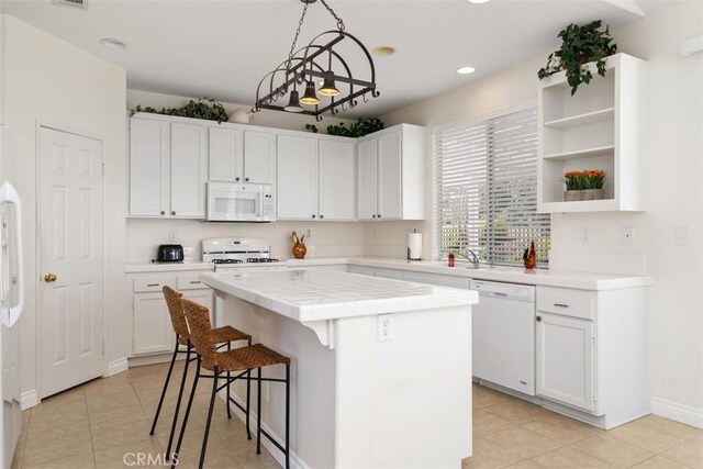 kitchen featuring white cabinetry, white appliances, tile countertops, and a kitchen island