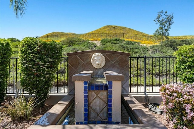 exterior space featuring a gate, a mountain view, and fence