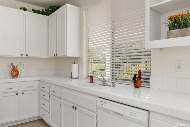 kitchen with a sink, white cabinets, and white dishwasher