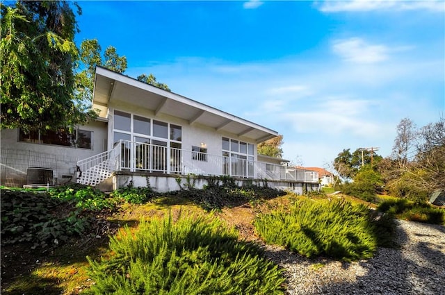 rear view of house featuring cooling unit and stucco siding