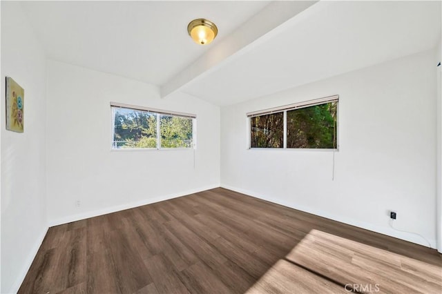 unfurnished room with beam ceiling, baseboards, and wood finished floors