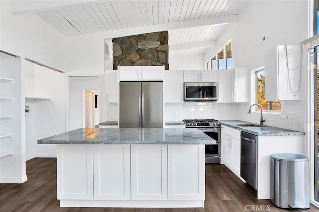 kitchen featuring tasteful backsplash, a sink, light stone counters, stainless steel appliances, and wooden ceiling