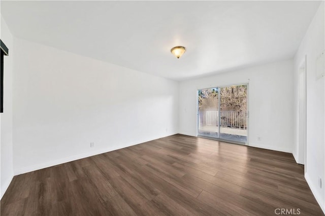 unfurnished room featuring dark wood-style floors and baseboards